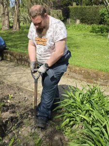 a student is shown digging with a garden fork