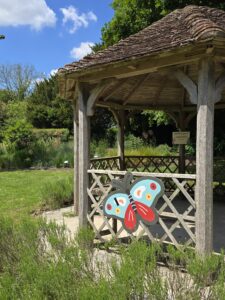 a cut out of a butterfly is shown attached to a small pavillion in a garden