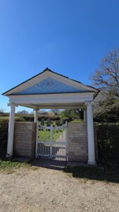 an entrance to a churchyard with a big white gate