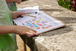 close up of a child's hands and a quiz sheet on a clipboard